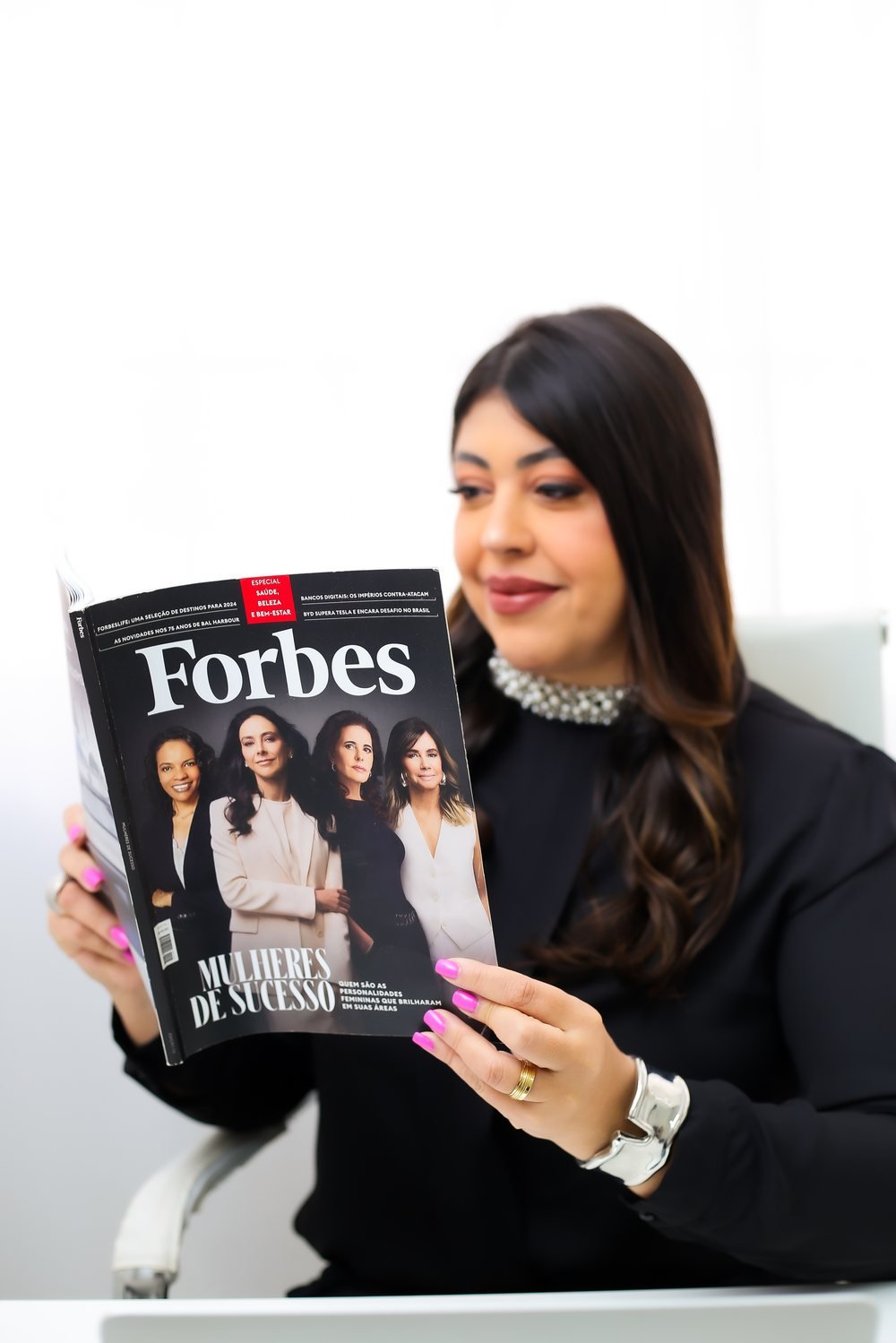 Elaine Buck lendo a revista Forbes